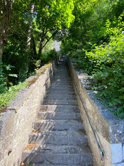 Dramatic perspective view of the steep staircase leading up to the Dinant citadel in Belgium, with stone steps and handrails under daylight.