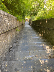 Dramatic perspective view of the steep staircase leading up to the Dinant citadel in Belgium, with stone steps and handrails under daylight.