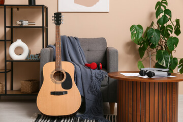 Modern acoustic guitar on floor in stylish living room