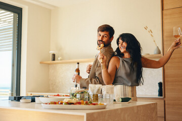 Couple enjoying fun moments in the kitchen while preparing a meal together