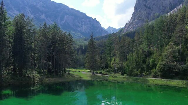 Aerial of alpine paradise emerald lake Gruner See with crystalline waters and pine forest. Summertime in Austria.