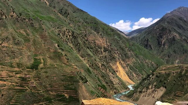 Chilam to Astore scenic route showing natural mountain landscape, snowy peaks, green hills, river-like stream, forest-covered slopes, and peaceful valley view captured from a high vantage point.