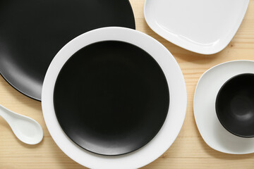 Table setting in white and black colors on wooden background