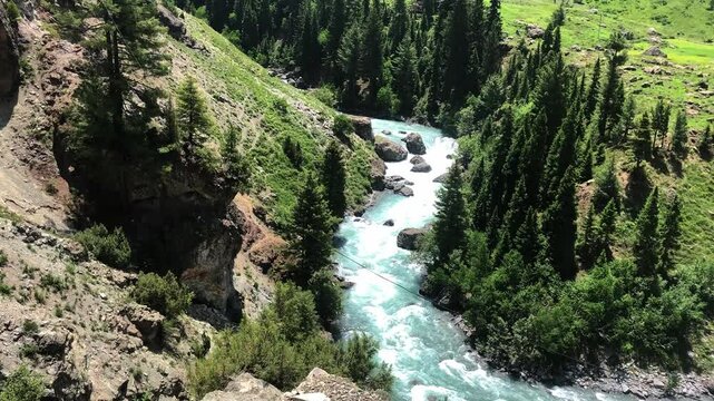 Gacier river flowing through the mountains of Astore Valley in Pakistan during a sunset afternoon in the summer
