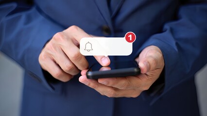 Businessperson using smartphone with notification bell alert appearing on screen indicating new message or update