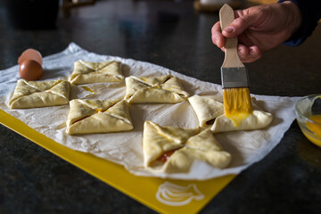 preparing filled puff pastrys for baking in the oven