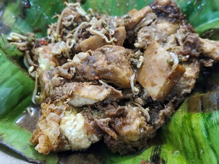 Tahu lontong, a delicious traditional Indonesian dish, lontong with peanut sauce, soy sauce, served with pieces of side dish on banana leaves.