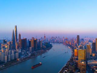 Aerial view of Shanghai skyline with winding river at sunrise.