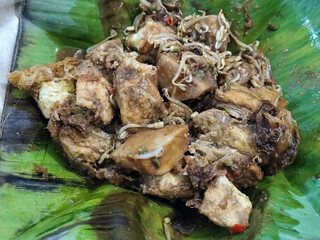 Tahu lontong, a delicious traditional Indonesian dish, lontong with peanut sauce, soy sauce, served with pieces of side dish on banana leaves.