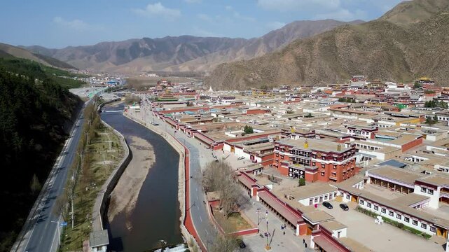 Xiahe, China: Aerial forward footage of the Tibetan Buddhism Labrang Monastery surrounded by a 3km long prayer wheel circuit in the Xiahe town in the Amdo region of Gansu on the Tibetan plateau