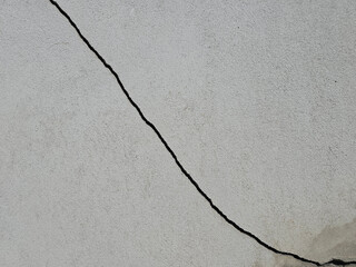 Significant diagonal cracks on cement walls or textured surfaces.