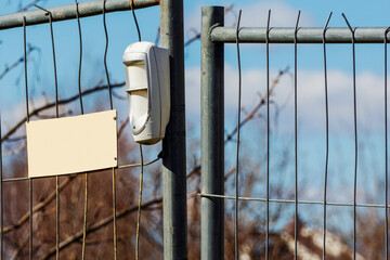 Wireless motion detector on a metal temporary fence