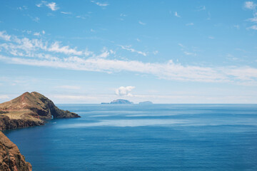Vast ocean view with rocky coast, distant islands, and blue sky
