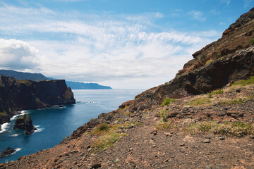 Dramatic coastal landscape of rocky cliffs and the Atlantic Ocean in Madeira under a cloudy sky