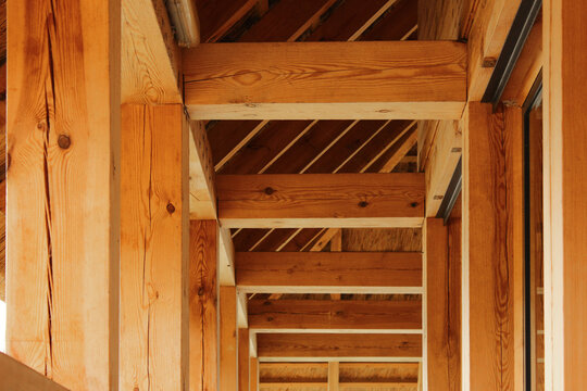 Heavy Timber Roof Structure with Thick Beams and Support Columns in Outdoor Wooden Architecture.