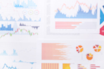 Many business graphics and diagrams as background, blurred view