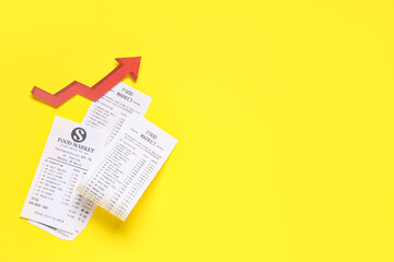 Naklejka premium Receipts from food market with red arrow on yellow background. Price rise concept