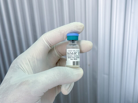 Thailand &ndash; June 19. 2025: Closeup of MSD or M-M-R II  vaccine vials. Medical hand grove dispose use prevention concept