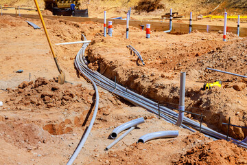 Gray electrical pipes lie at construction site ready for installation underground industrial mood.