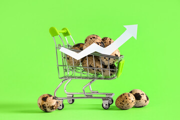 Shopping cart with quail eggs and arrow on green background. Price rise concept