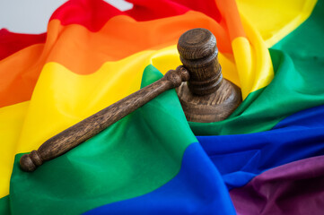 Judge's gavel and hammer on a rainbow flag. 