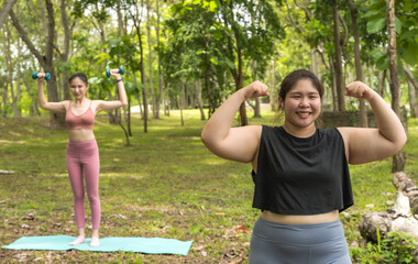 Asian fat sportswoman doing exercise yoga in park with female trainer