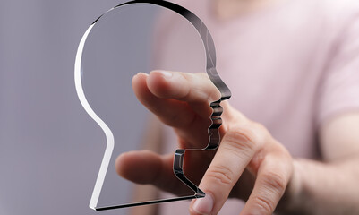 Hand reaching towards a clear head shape, symbolizing ideas, thoughts, or understanding.