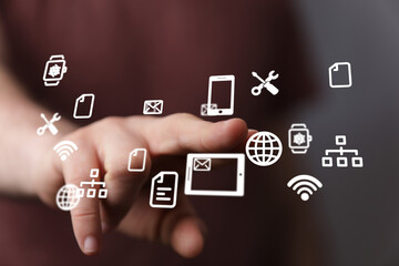 Image depicts a hand interacting with various digital icons, representing technology, connectivity,...