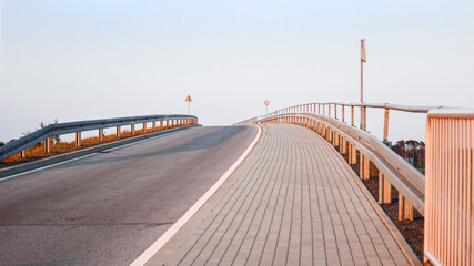 Road and Pedestrian Walkway on a Viaduct with Safety Barriers Under a Clear Blue Sky