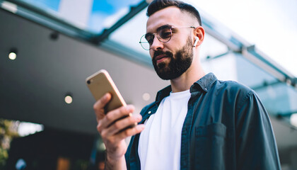 Connected Gaze: A focused individual, immersed in the digital world, engages with his smartphone while looking thoughtful. Capturing a moment of modern connectivity and contemplation.