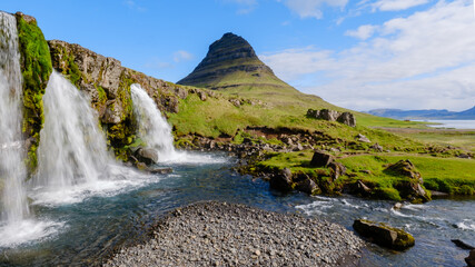 Majestic Kirkjufell mountain surrounded by cascading waterfalls in Icelands serene landscape