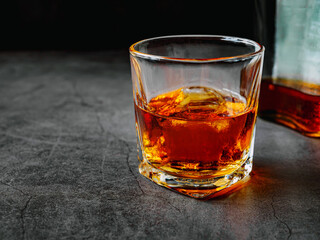 Strong alcohol drink and whiskey bottle Whisky in glass with ice, Whisky, bourbon or cognac. Hard...