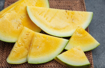 Pieces of ripe yellow watermelon on table, closeup
