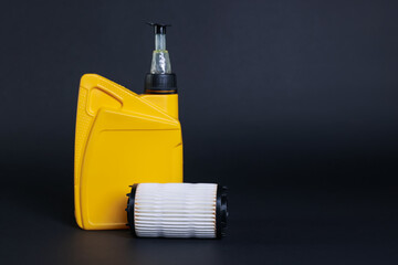 Motor oil in plastic canister and filter on dark grey background, space for text