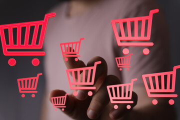Hand interacting with digital shopping carts.  E-commerce, online retail, digital marketing.