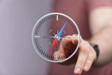 Person using a digital compass, navigation, direction, guidance, travel, exploration, technology.