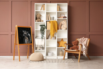 Interior of children's room with shelf unit, chalkboard and armchair