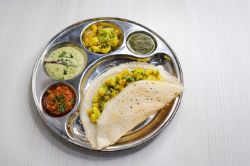 Crispy Masala dosa is a popular South Indian food item served with tomato chutney, coconut chutney, spicy potato masala, or aloo ki sabzi and sambar. Copy space. Crunchy Rice crepes.