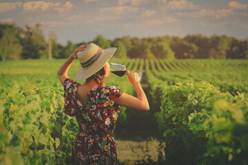 Asian woman drinking red wine at vineyard during her vacation