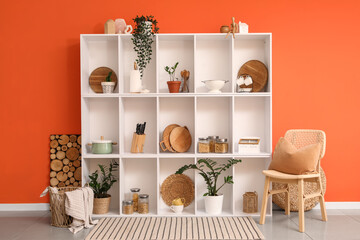 Interior of kitchen with shelf unit, chair and plants