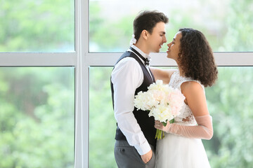 Young couple near window on their wedding day