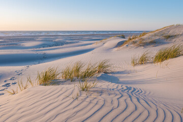 Serenity on the sandy shores of Denmark at sunset with gentle ocean waves
