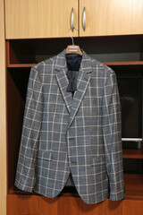 Stylish men's suit and bow tie on a hanger.