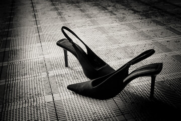 Abandoned Black High Heels on a Tiled Floor