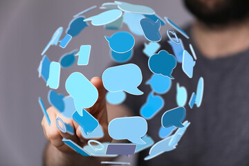 Conceptual image of a person interacting with a sphere of speech bubbles, representing global...