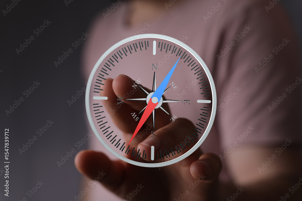 Poster close-up of hand interacting with a digital compass app, showing direction and navigation.