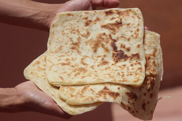 Hands holding Moroccan Msemmen or Msemen, Traditional moroccan flatbread