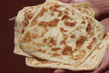Hands holding Moroccan Msemmen or Msemen, Traditional moroccan flatbread