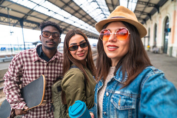 Group of young tourists taking selfie at train station