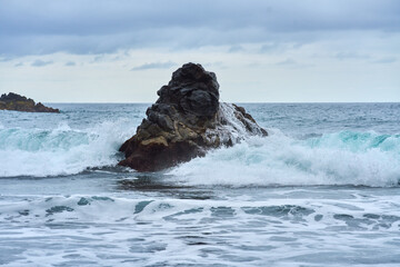 Waves crashing on volcanic rock